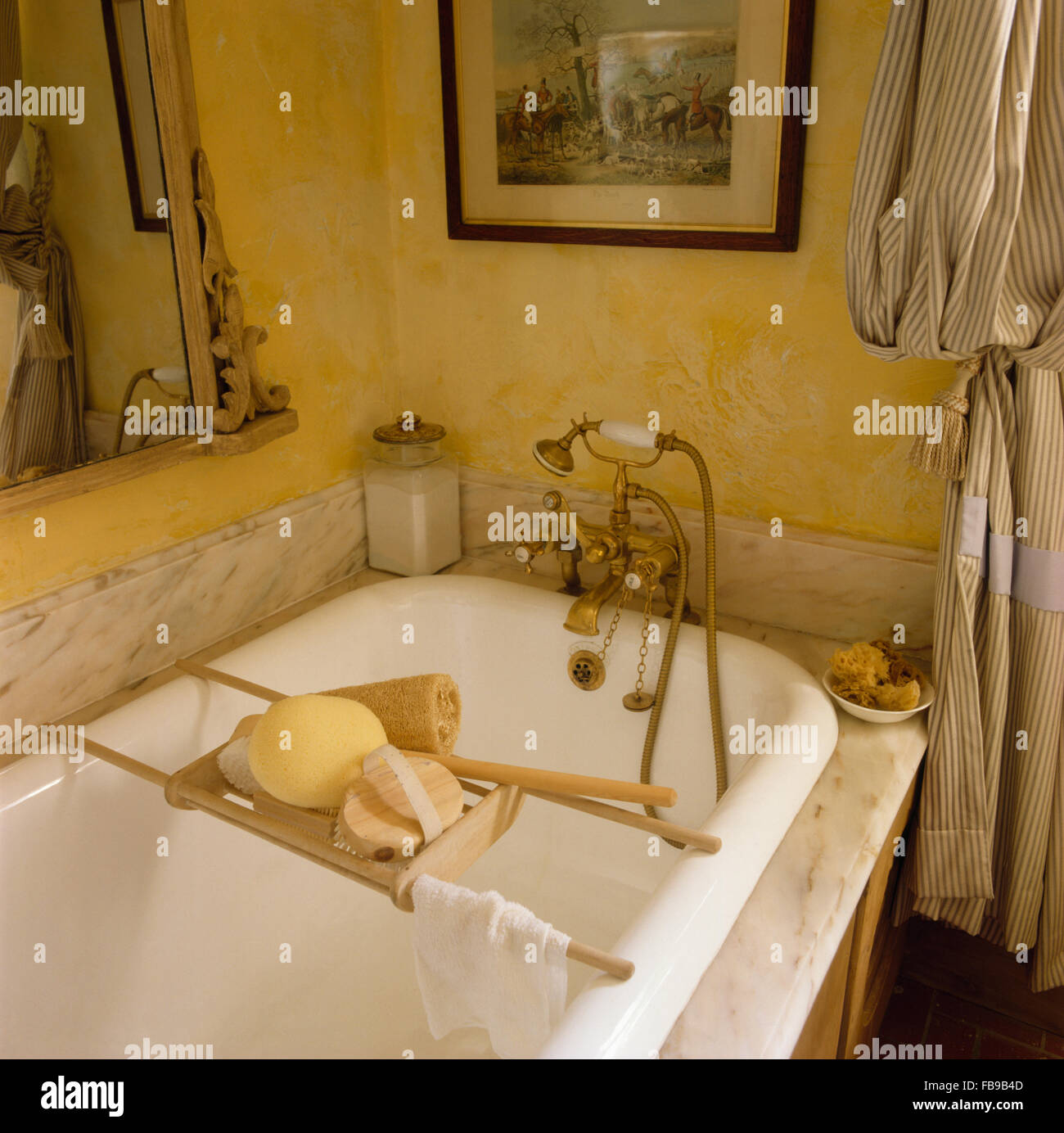 Bagno in legno rack e ottone rubinetti doccia su vasca da bagno in marmo con surround degli anni ottanta in bagno Foto Stock