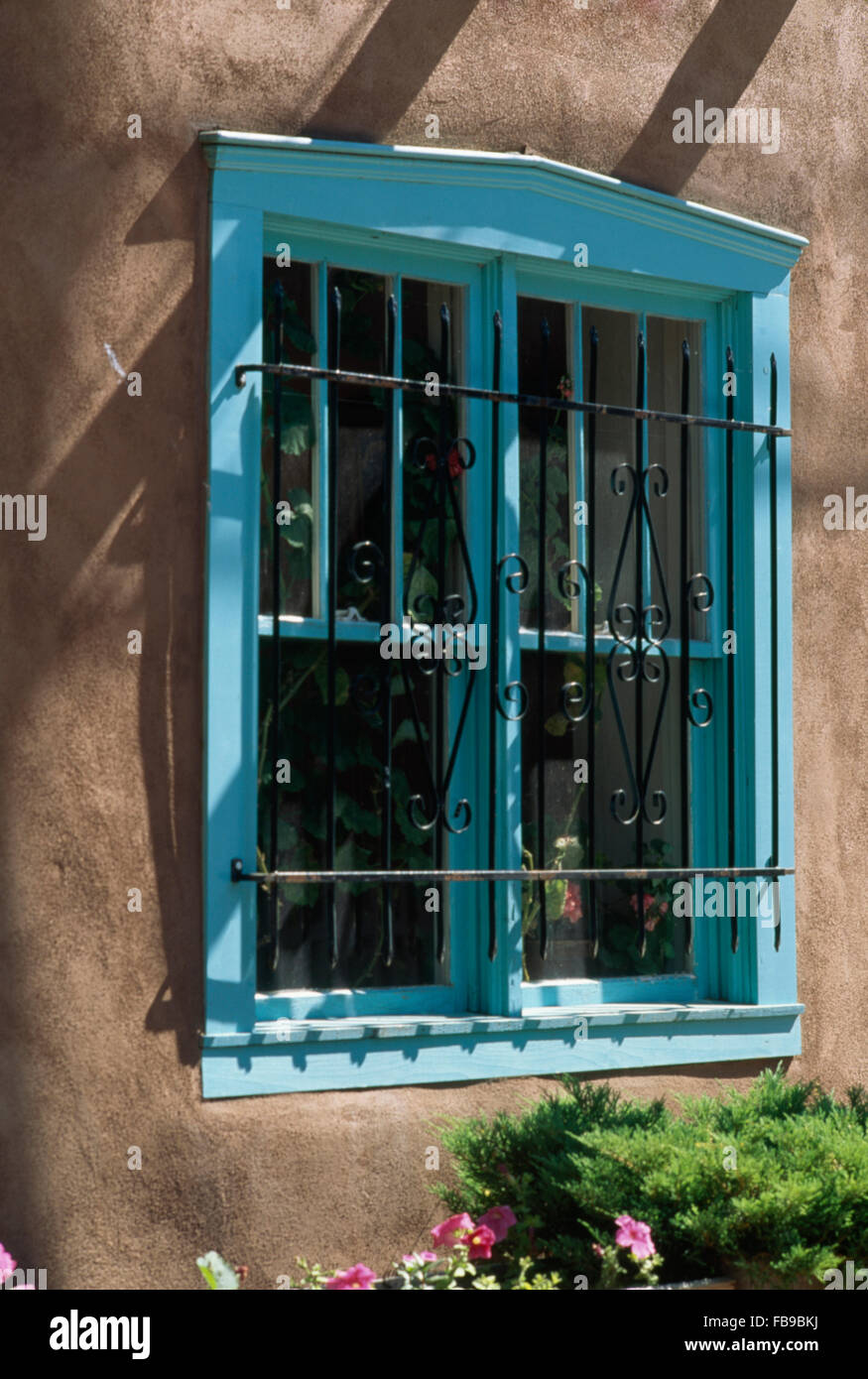 Close-up di una villa Messicana con turchesi finestra dipinte con barre di sicurezza Foto Stock
