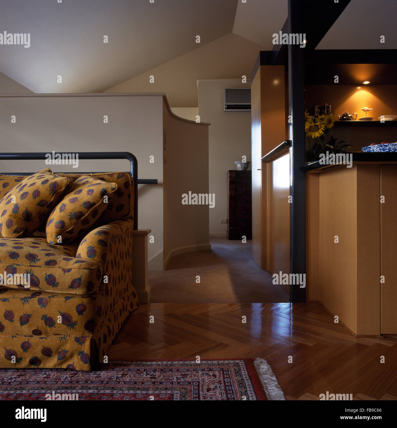 Parquet in un piano aperto di conversione loft cucina e soggiorno con un modellato divano giallo Foto Stock