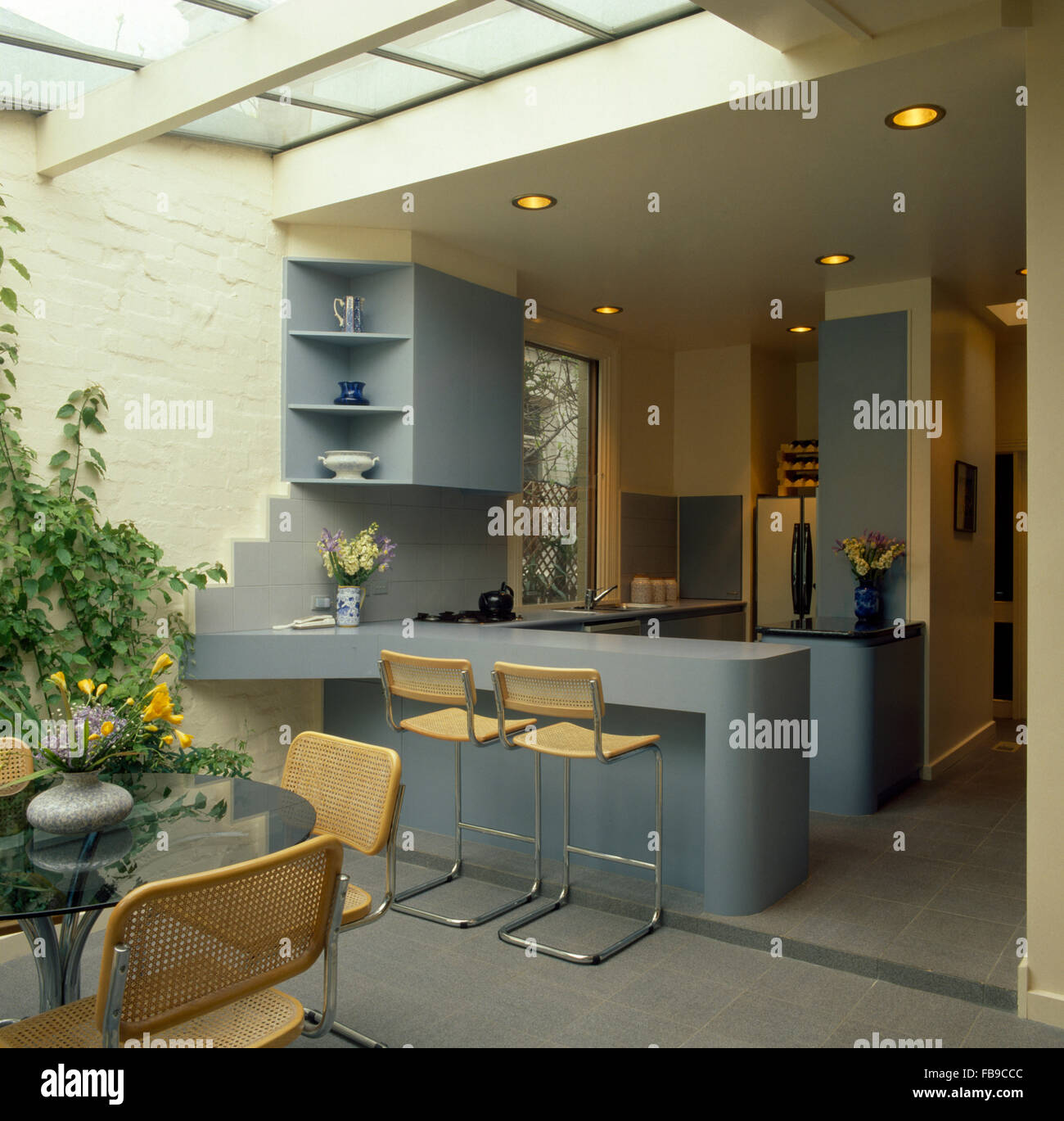 Schienale in canna sedie e vetro tavolo da pranzo in novanta architettonico  interno cucina con sgabelli in blu pallido bar per la prima colazione Foto  stock - Alamy