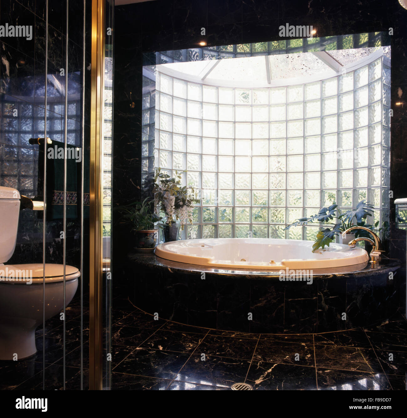 Bagno termale e vetro curvo di parete di mattoni degli anni novanta in bagno Foto Stock