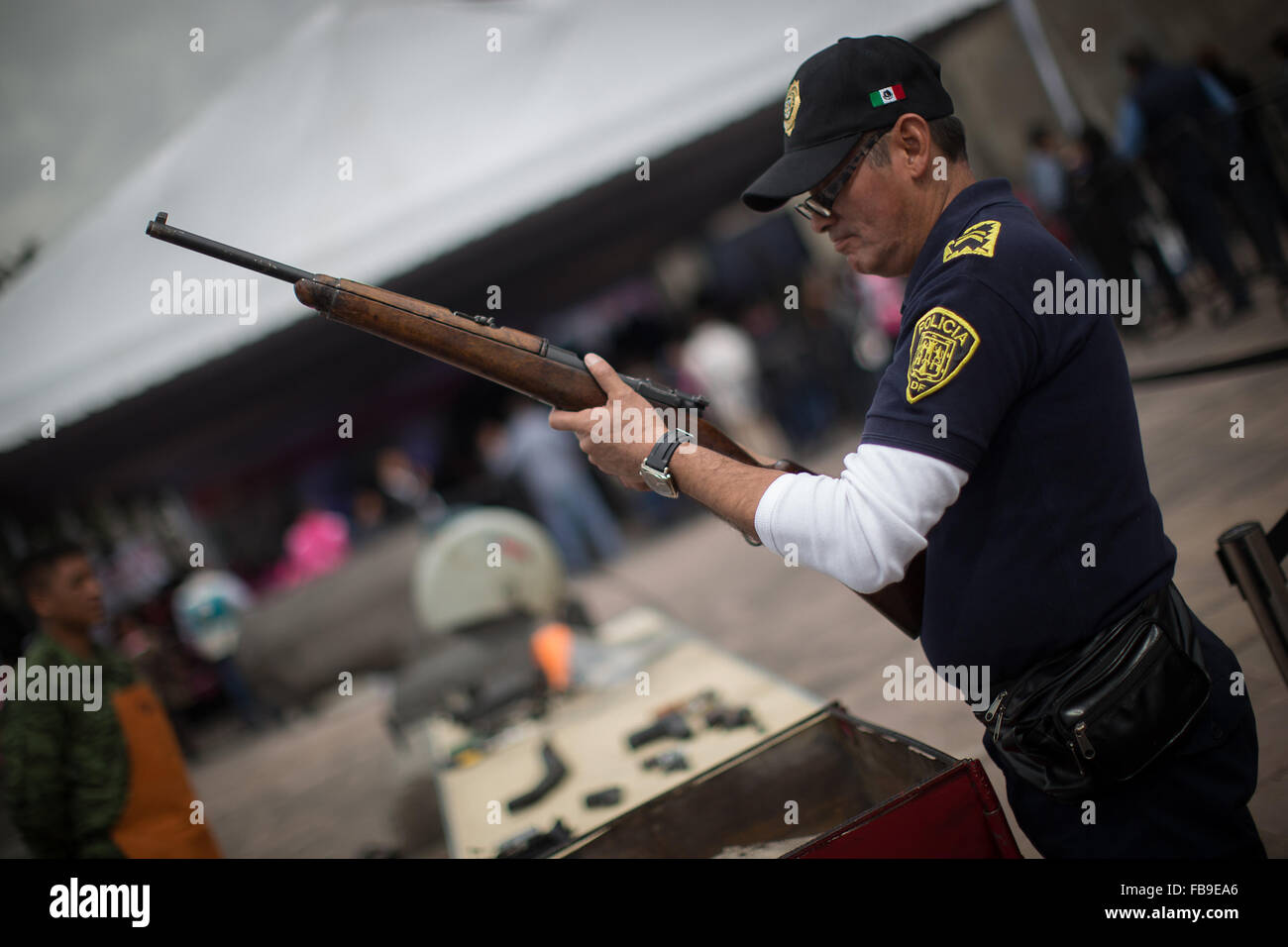 (160112) -- CITTÀ DEL MESSICO, Gennaio 12, 2016 (Xinhua) -- un poliziotto controlla un arma durante la sesta tappa del programma " Per la vostra famiglia, disarmo volontario', alla Cattedrale Metropolitana, a Città del Messico, capitale del Messico, a gennaio 12, 2016. Secondo la stampa locale il governo del Distretto Federale (GDF, per il suo acronimo in spagnolo), effettuata la sesta fase di scambio di armi attraverso il programma "Per la vostra famiglia, disarmo volontario', in cui le persone possono scambiare armi e pistole giocattolo per denaro, disposizioni e dispositivi elettronici. Le armi scambiati sono oggetto di revisione da parte dei membri del Foto Stock
