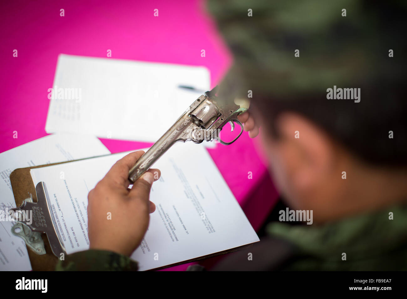 (160112) -- CITTÀ DEL MESSICO, Gennaio 12, 2016 (Xinhua) -- Un uomo militare classifica un arma durante la sesta tappa del programma " Per la vostra famiglia, disarmo volontario', alla Cattedrale Metropolitana, a Città del Messico, capitale del Messico, a gennaio 12, 2016. Secondo la stampa locale il governo del Distretto Federale (GDF, per il suo acronimo in spagnolo), effettuata la sesta fase di scambio di armi attraverso il programma "Per la vostra famiglia, disarmo volontario', in cui le persone possono scambiare armi e pistole giocattolo per denaro, disposizioni e dispositivi elettronici. Le armi scambiati sono esaminati dai membri Foto Stock