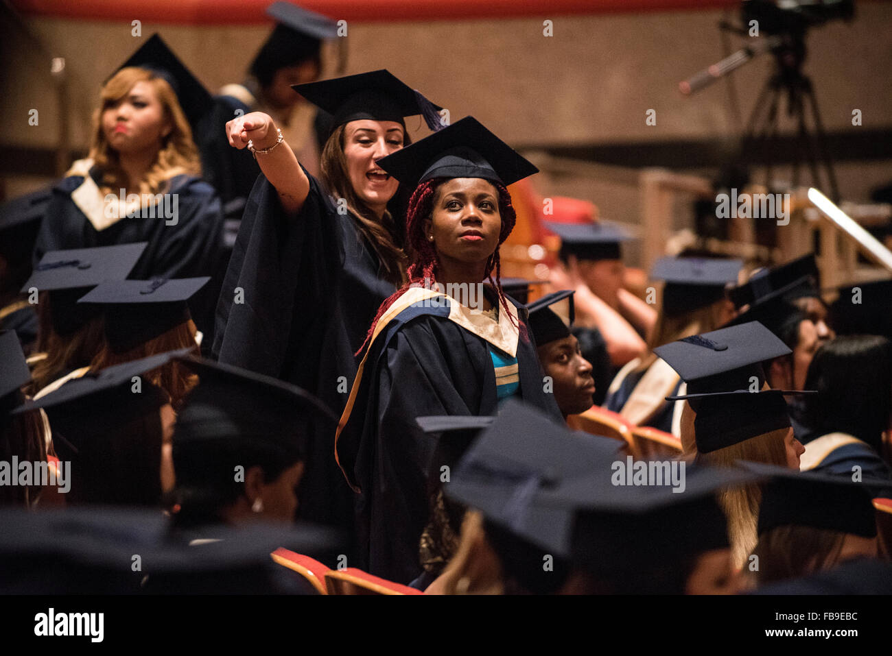 Giovane femmina punto di lavoro laureandi per famiglie e amici alla cerimonia di laurea, REGNO UNITO Foto Stock