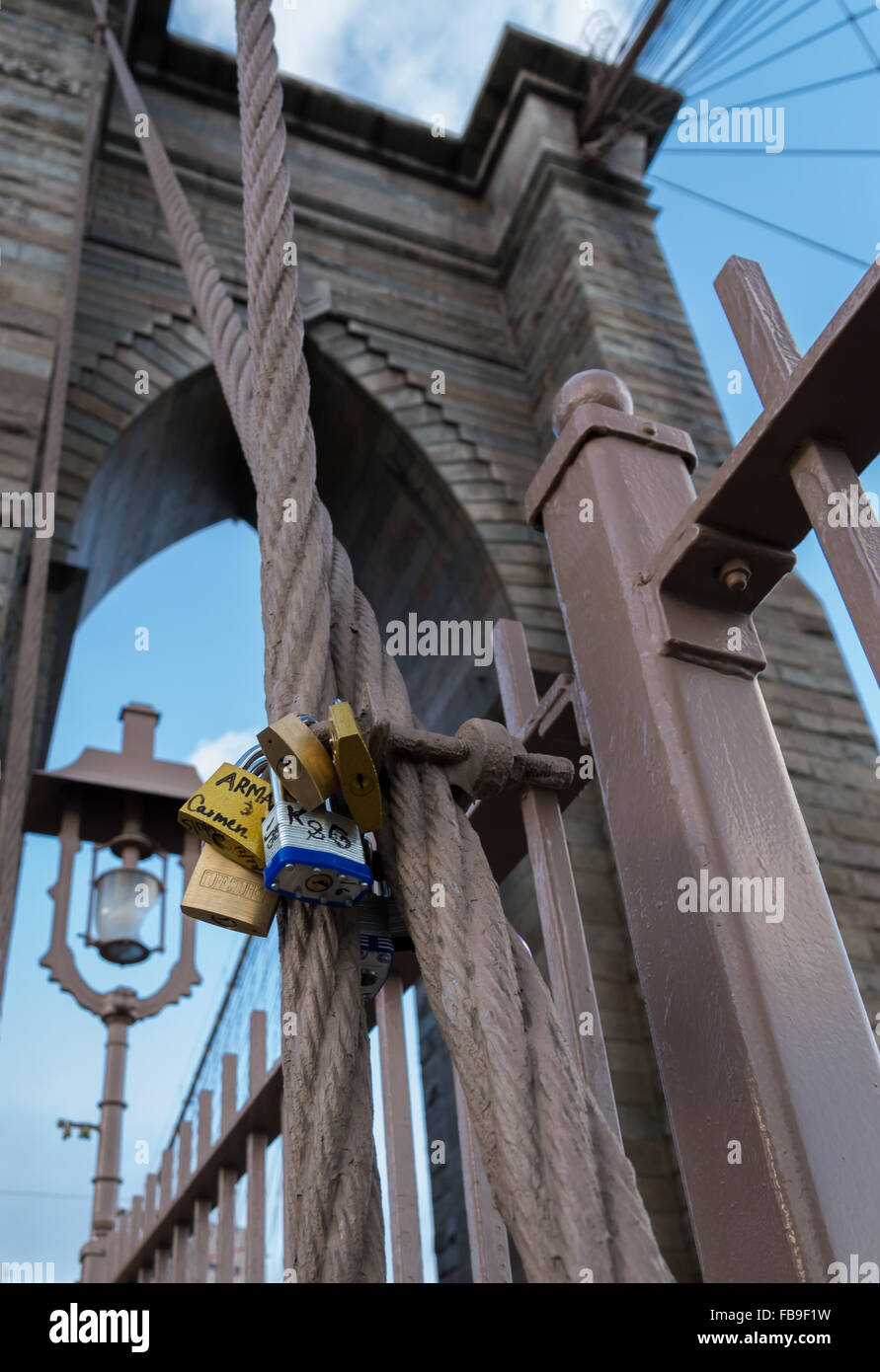 Amore serrature e lucchetti che le persone hanno attaccato al ponte di Brooklyn a New York City con la torre in background Foto Stock