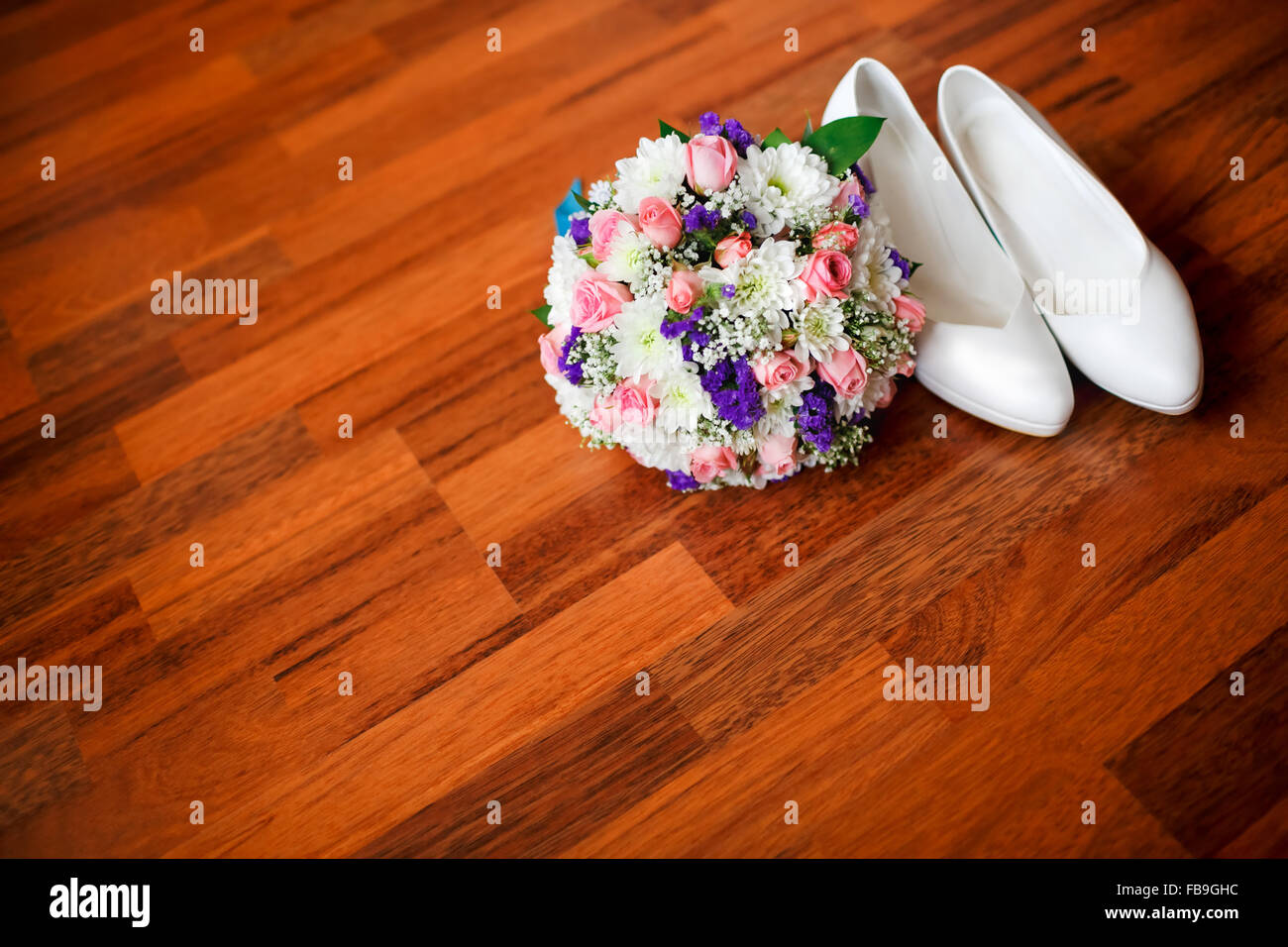 Bouquet nozze con fiori viola e bianco della sposa scarpe matrimonio sul pavimento in parquet, camera per copia. Accessori per la sposa. Foto Stock
