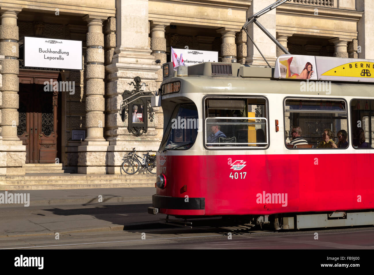 Un vecchio stile tram rosso nella parte anteriore del Burgtheater di Vienna in Austria Foto Stock