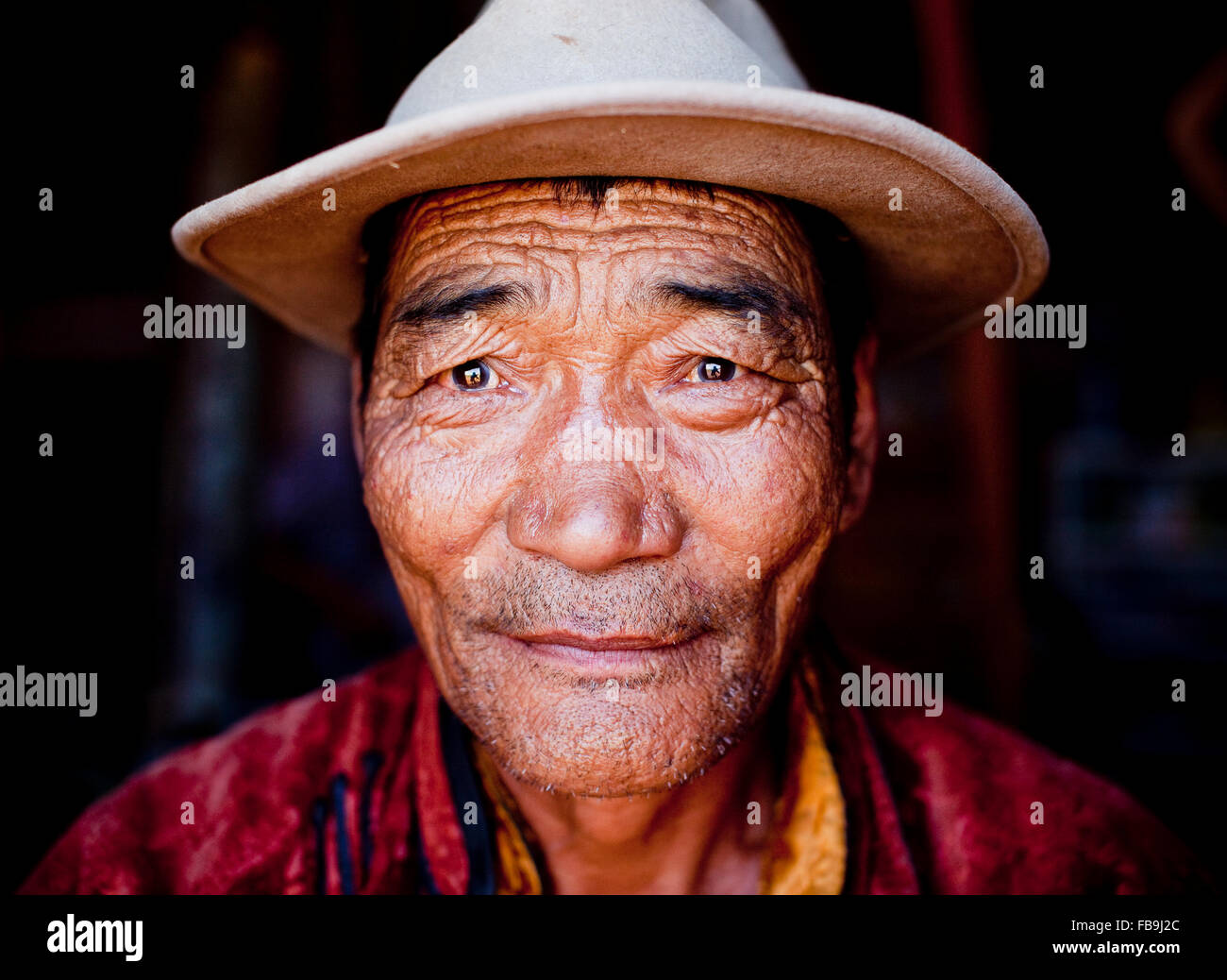 Una vita spesa sotto l eterna blue sky incapsulato nel volto di un anziano nomade in Mongolia del deserto del Gobi. Foto Stock
