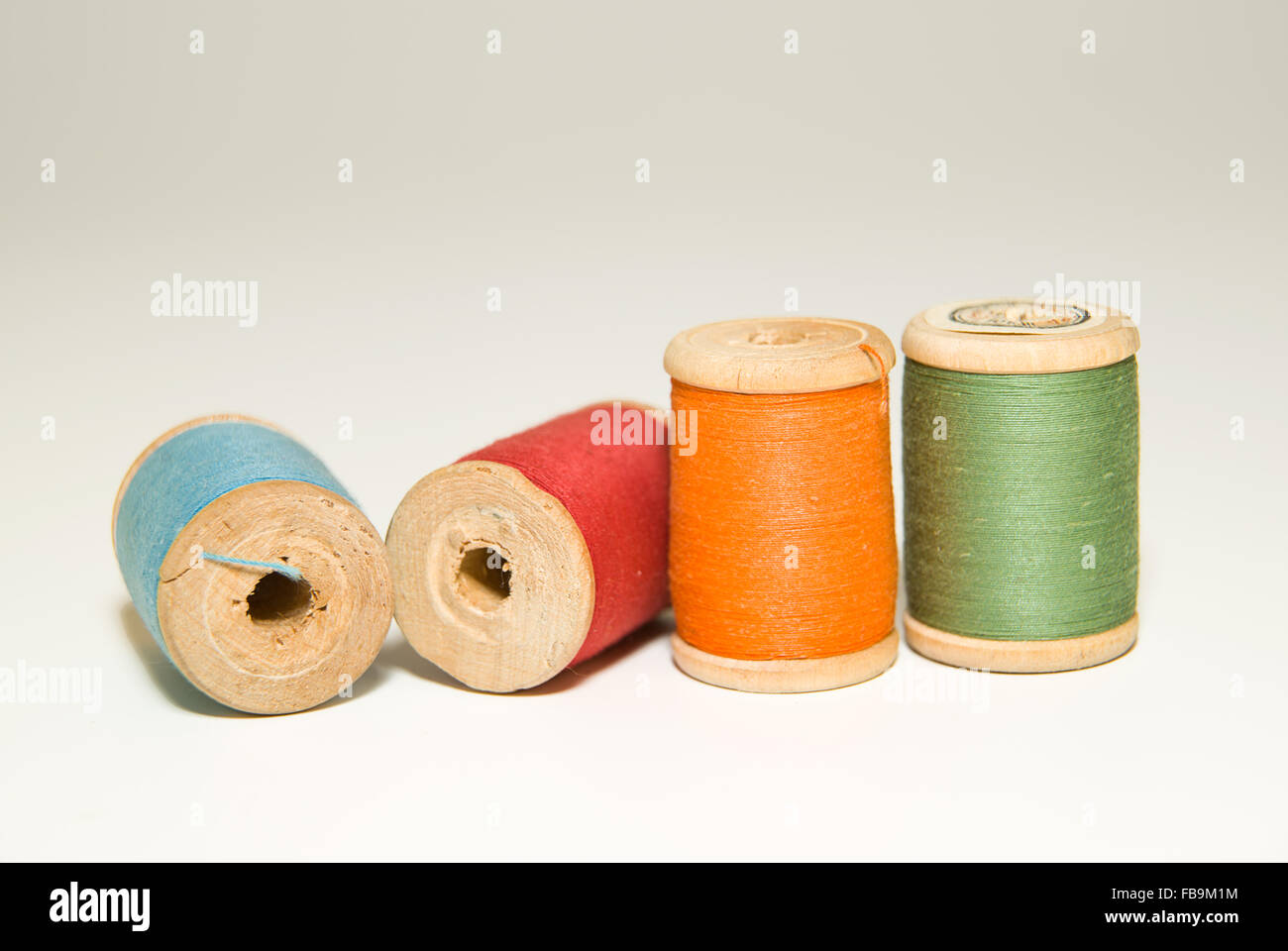 Diverse bobine di filo di diversi colori su bianco Foto Stock