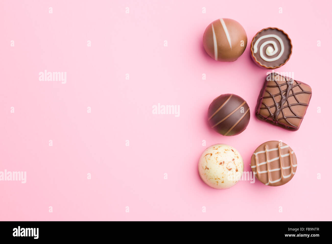 Praline di cioccolato su sfondo rosa Foto Stock