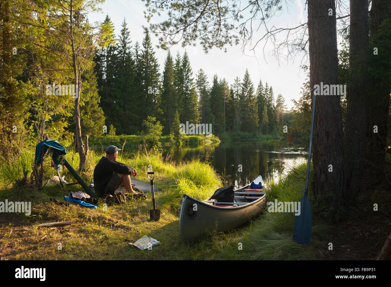 La Svezia, Vastmanland, Svartalven, Uomo seduto in canoa sul fiume Foto Stock