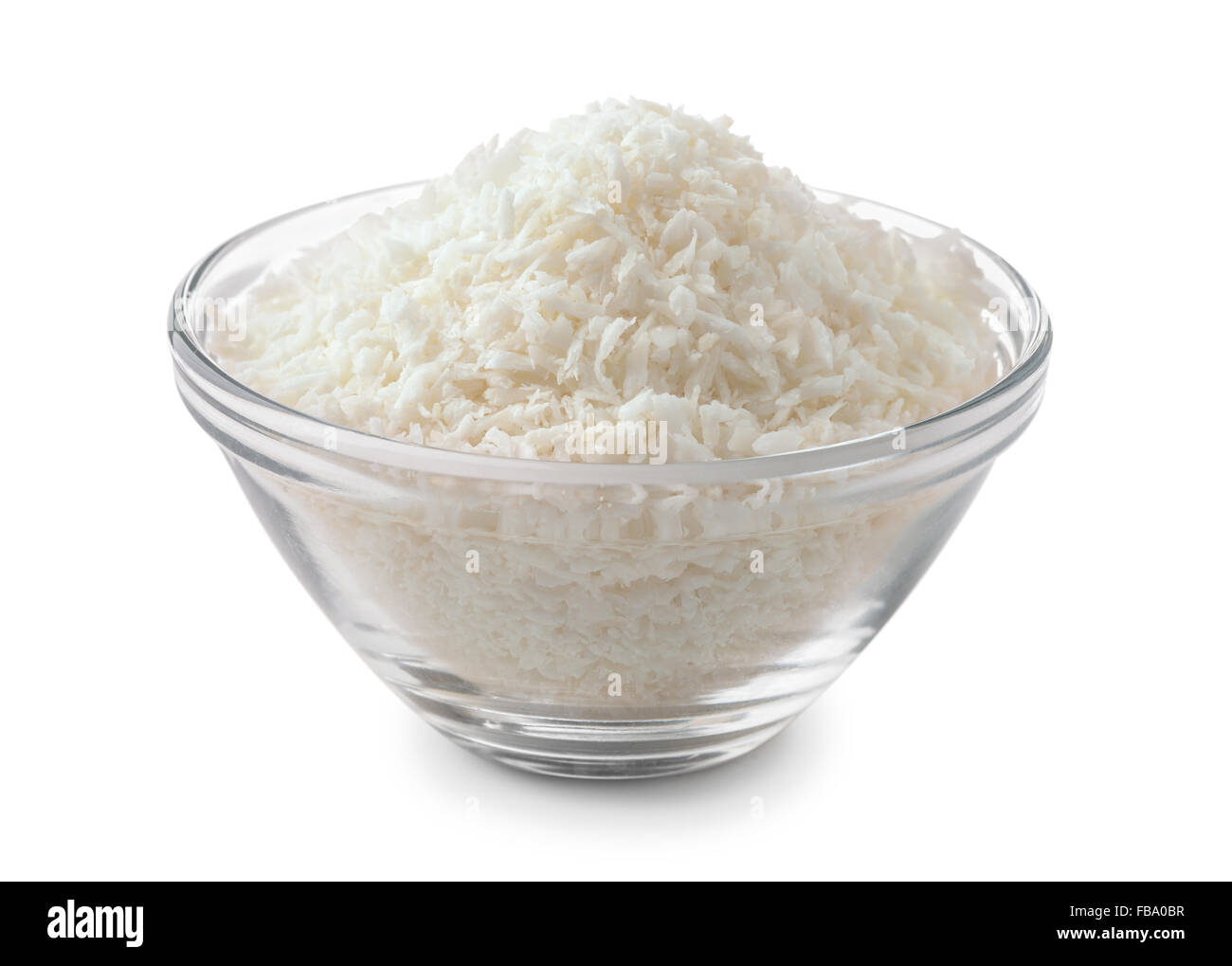 Ciotola di vetro di scaglie di cocco isolato su bianco Foto Stock