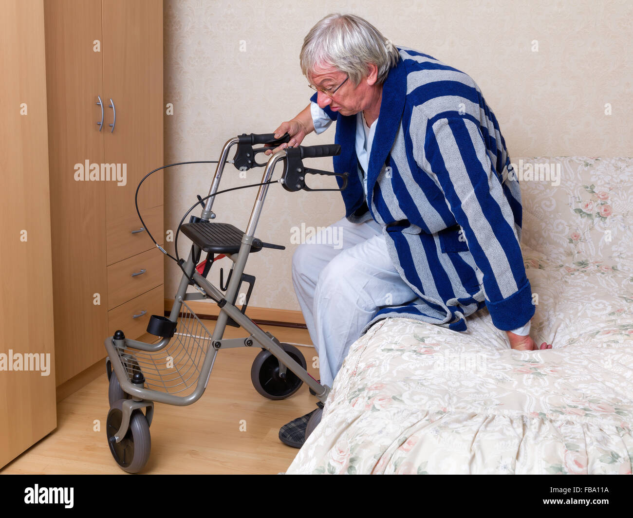 Anziani nonno in casa di cura utilizzando un rollator nel suo pigiama Foto  stock - Alamy