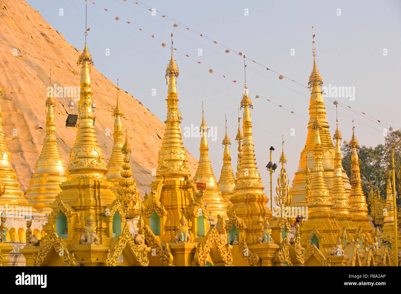 Guglie dorate di fronte alla stupa dorato di Shwedagon Paya, Yangon, Myanmar Foto Stock Guglie dorate di fronte alla stupa dorato di Shwedagon Paya, Yangon, Myanmar Foto Stock