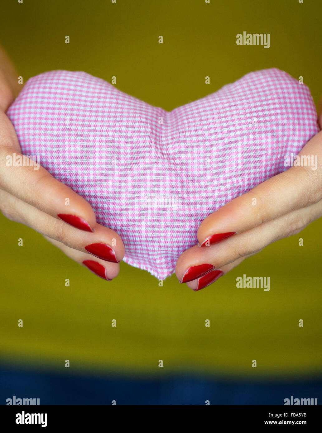 Primo piano sul cuore rosa in mano di donna. Immagine del giorno di San Valentino Foto Stock