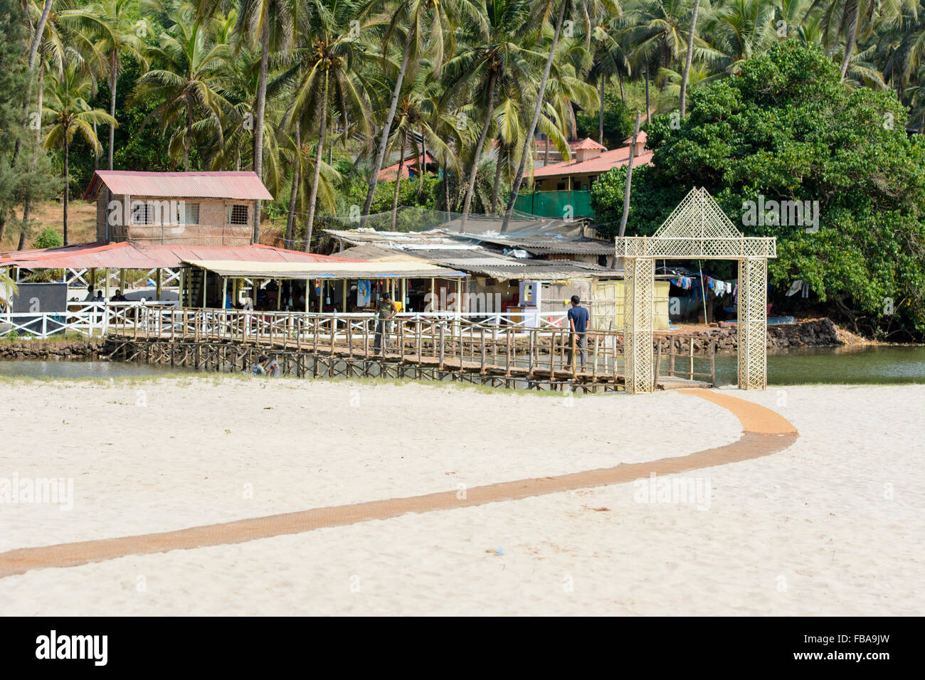 Ponte di legno che conduce alla spiaggia di Mandrem, Nord Goa, India Foto Stock