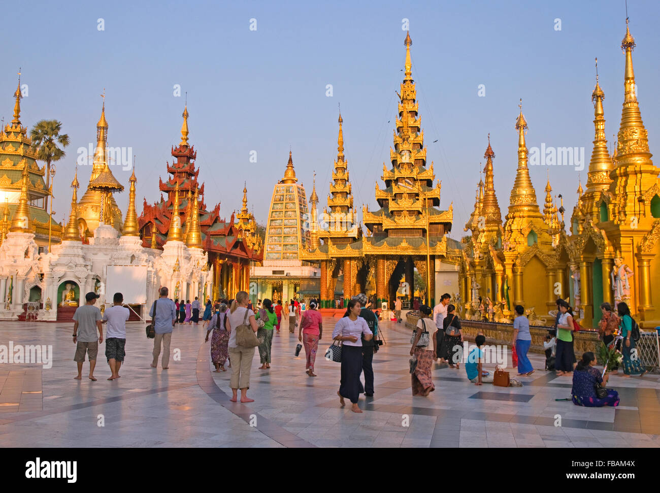 Turisti e persone in preghiera al tramonto in Shwedagon Paya, Yangon, Myanmar Foto Stock