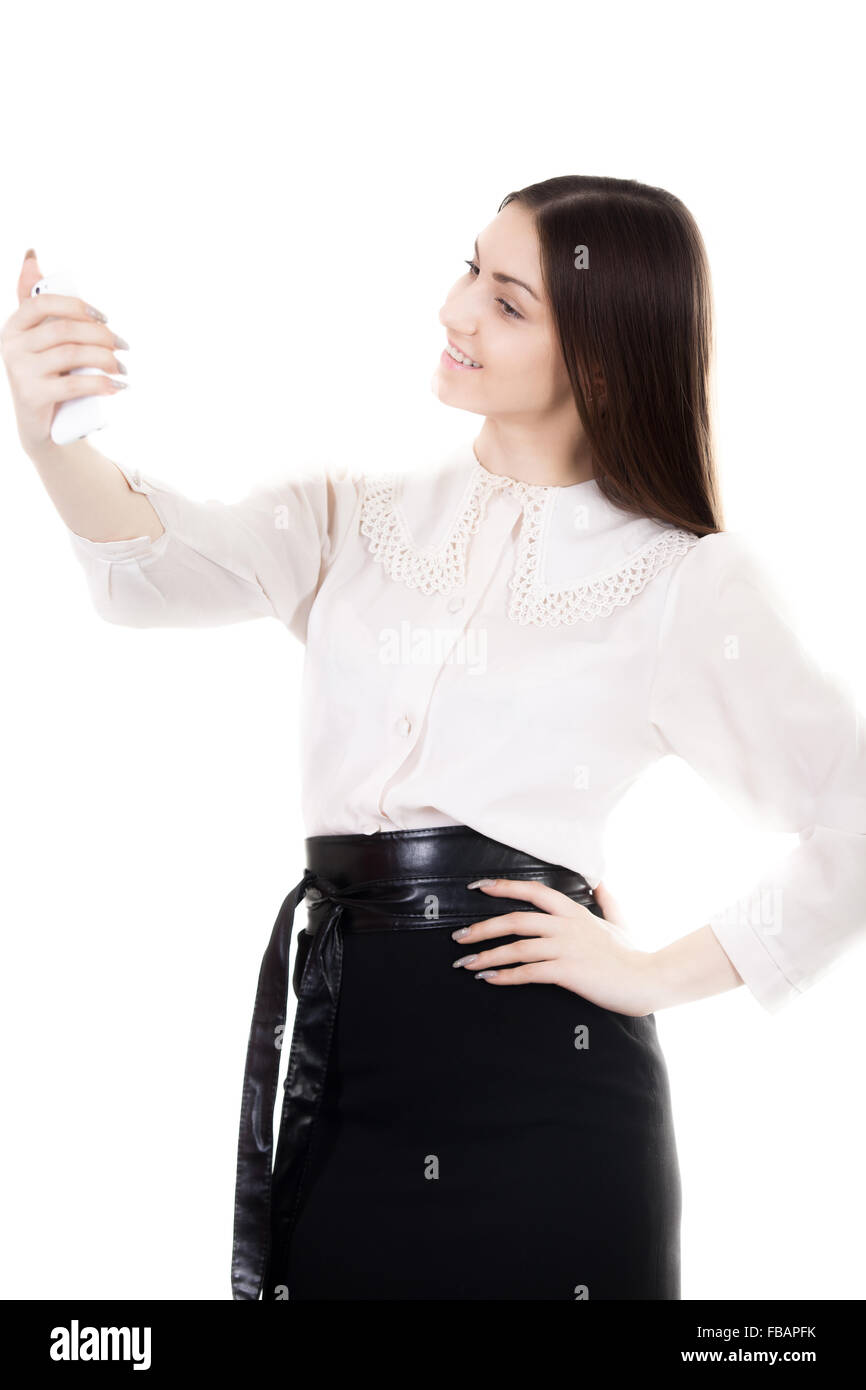 Felice bella ragazza in gonna nera e camicia bianca uniforme, lavoratore di  ufficio tramite telefono mobile app, prendendo foto, selfie, self Foto  stock - Alamy
