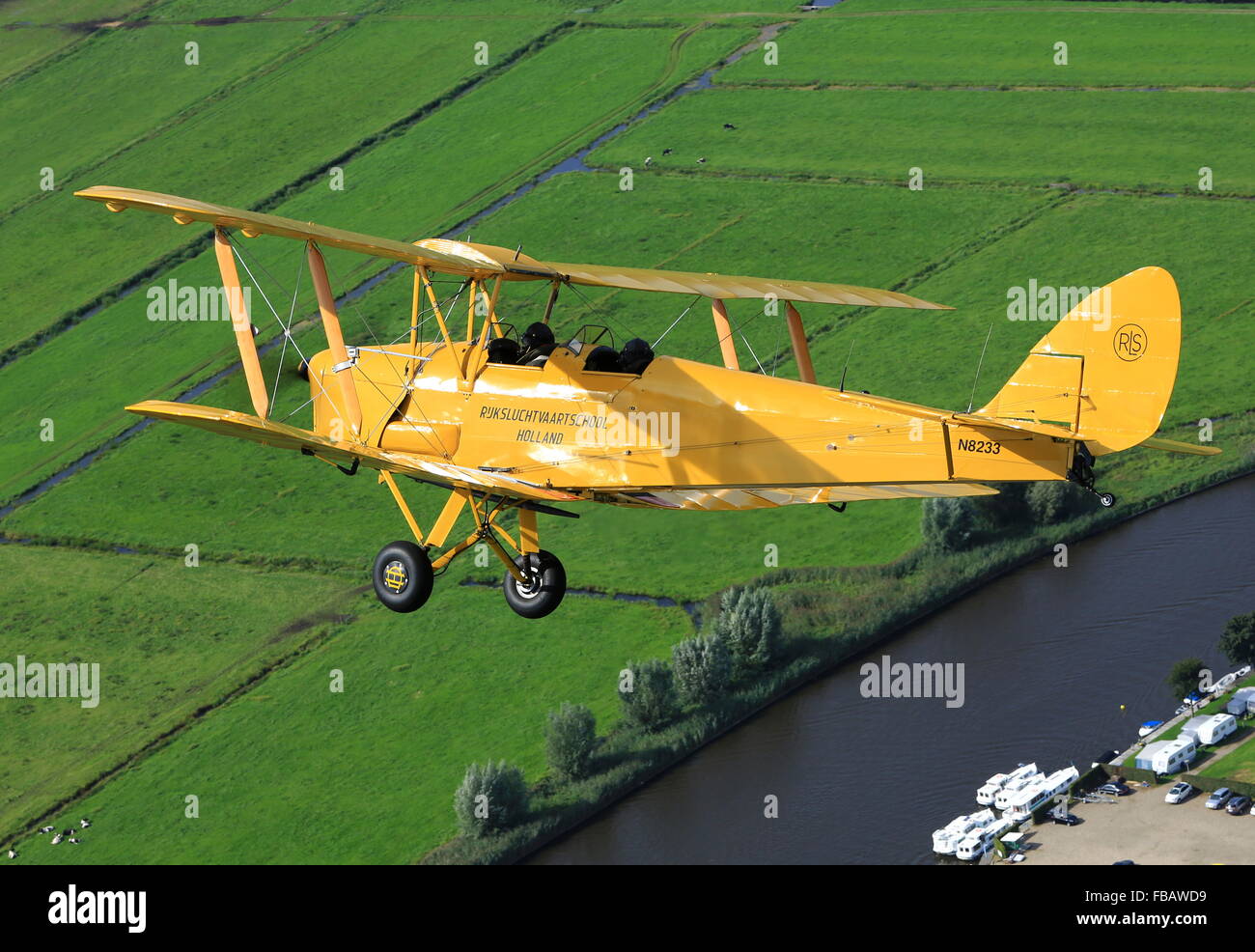 Un de Havilland Tiger Moth bi-piano oltre la campagna Olandese Foto Stock