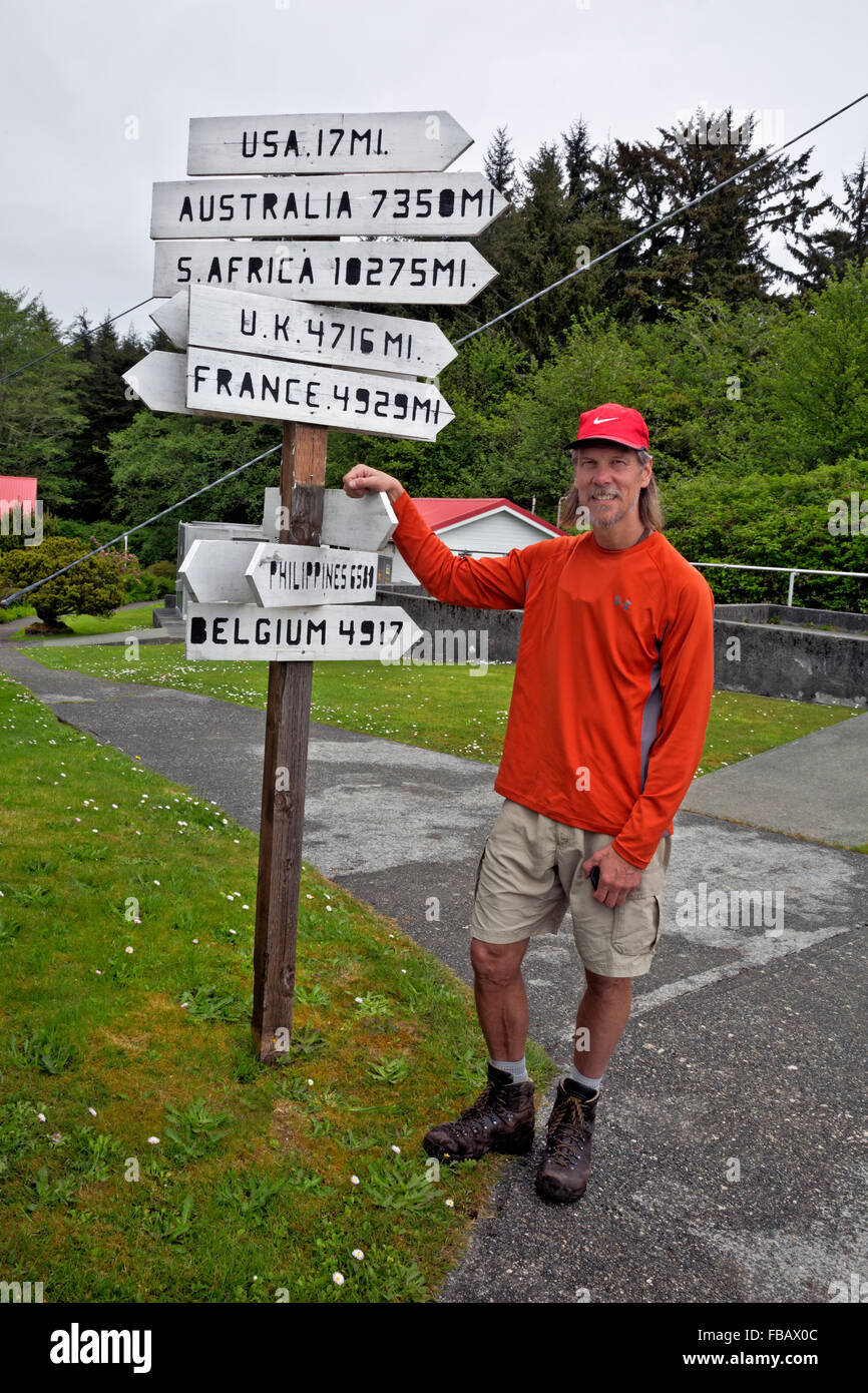 BRITISH COLUMBIA - West Coast Trail escursionista checking out l'utile segno direzionale a Pachena Point Lighthouse. Foto Stock