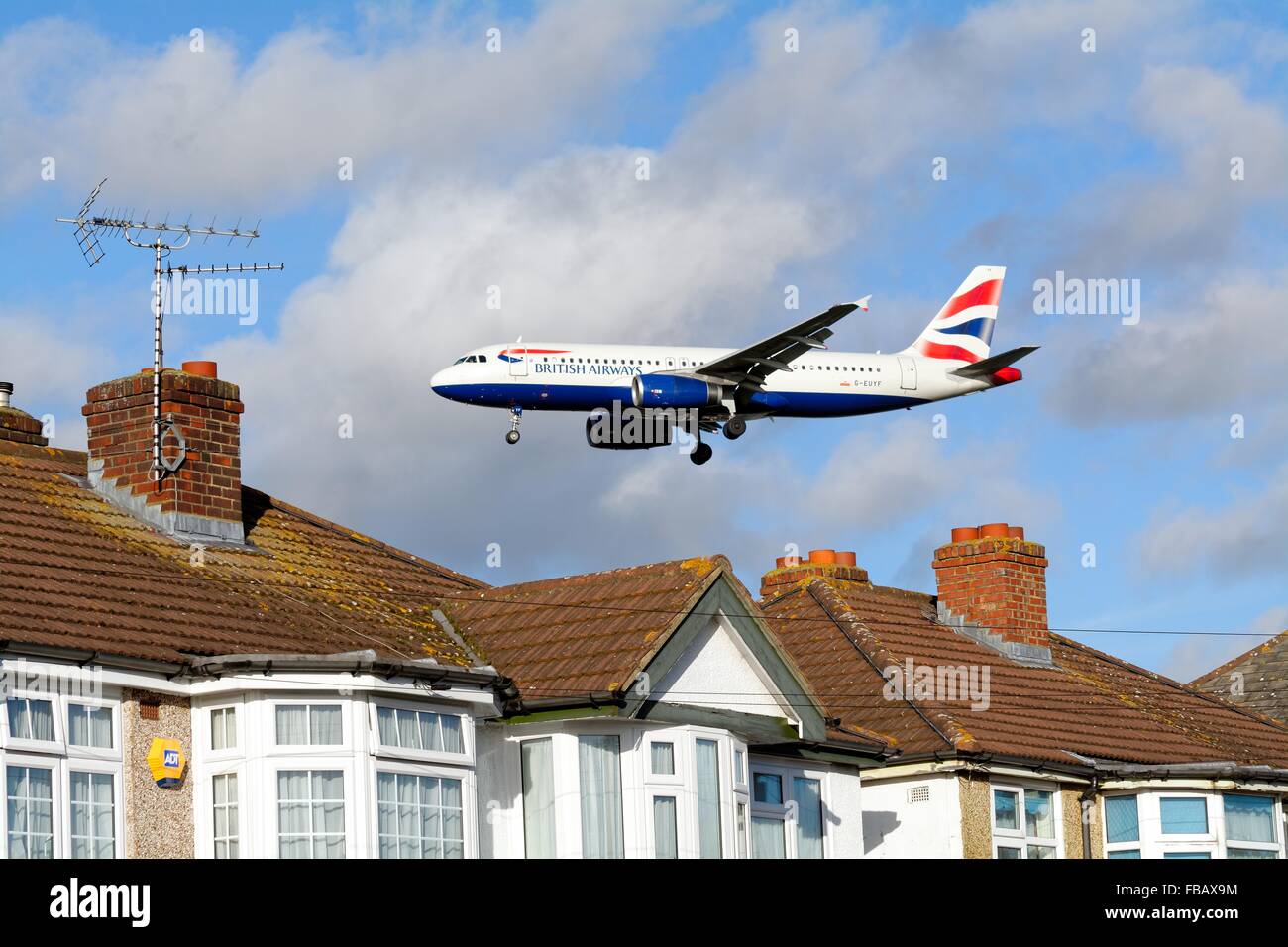 British Airways Airbus 320 volare sopra i tetti a Hatton Cross London Foto Stock