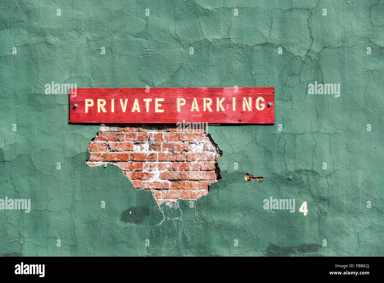Primo piano di un parcheggio privato segno su un vecchio muro verde in Wallace, Idaho Foto Stock