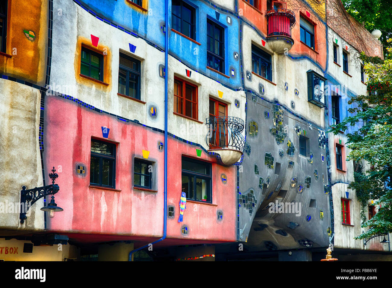 Basso Angolo di visione di un dipinto luminosamente Esterno della casa con finestre irregolari e balconi, Casa Hundertwasser, Vienna, Austria Foto Stock