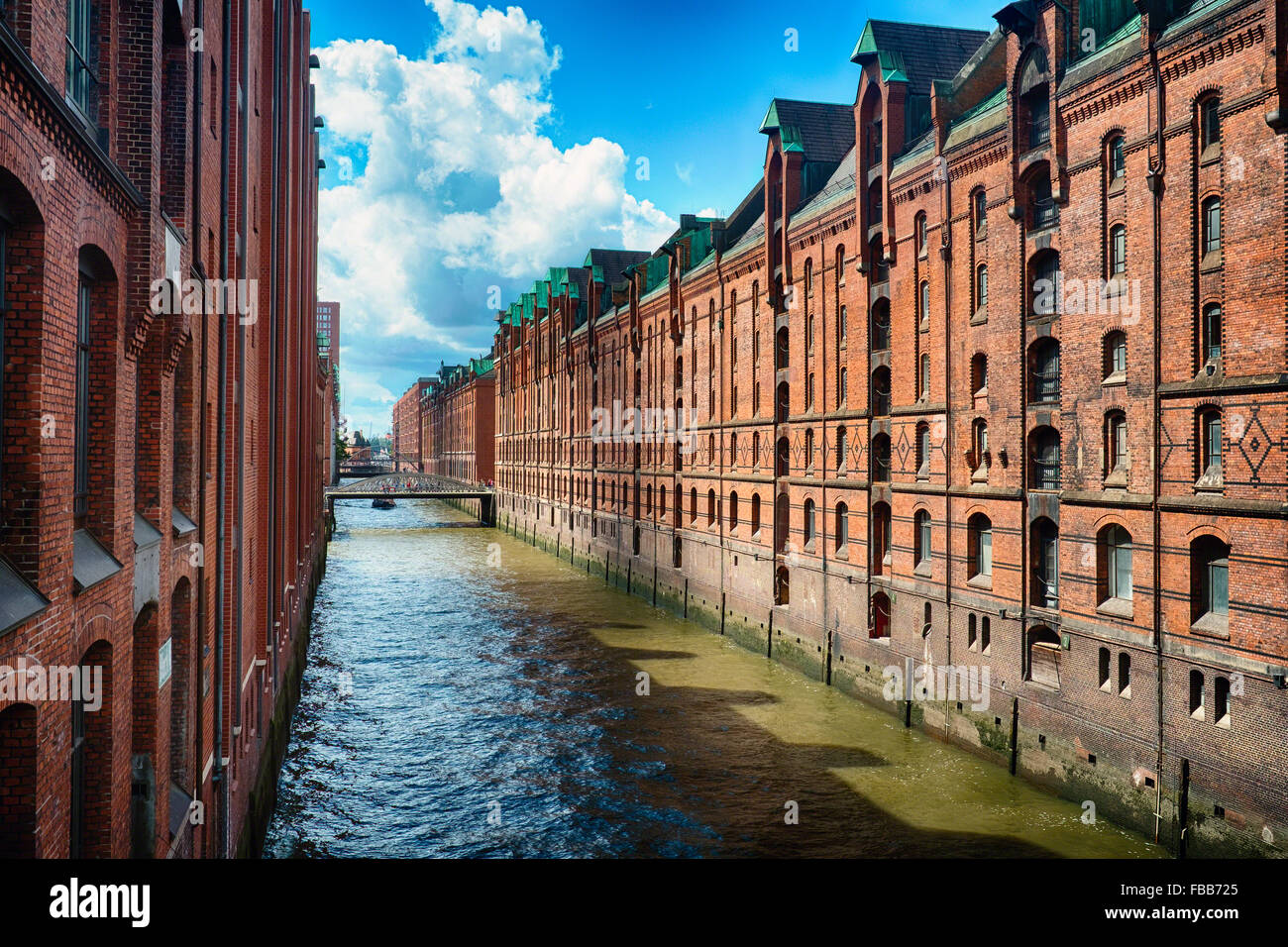 Vista di una fila di mattoni rossi depositi lungo un canale, Speicherstadt, Amburgo, Germania Foto Stock