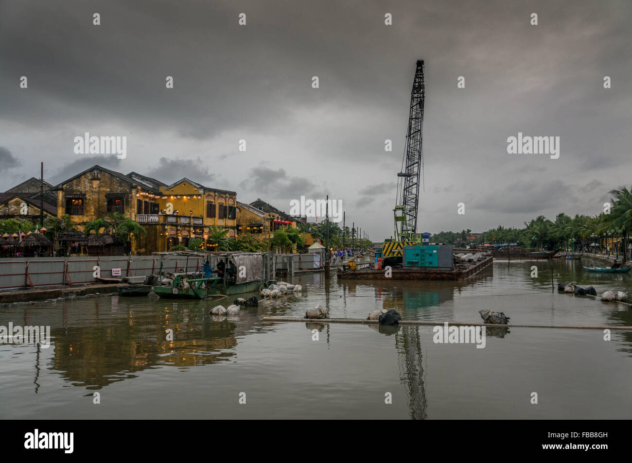 Il fascino industriale vicino alla antica città di Hoi An, Vietnam. Cielo drammatico e riflessi nel fiume. Foto Stock