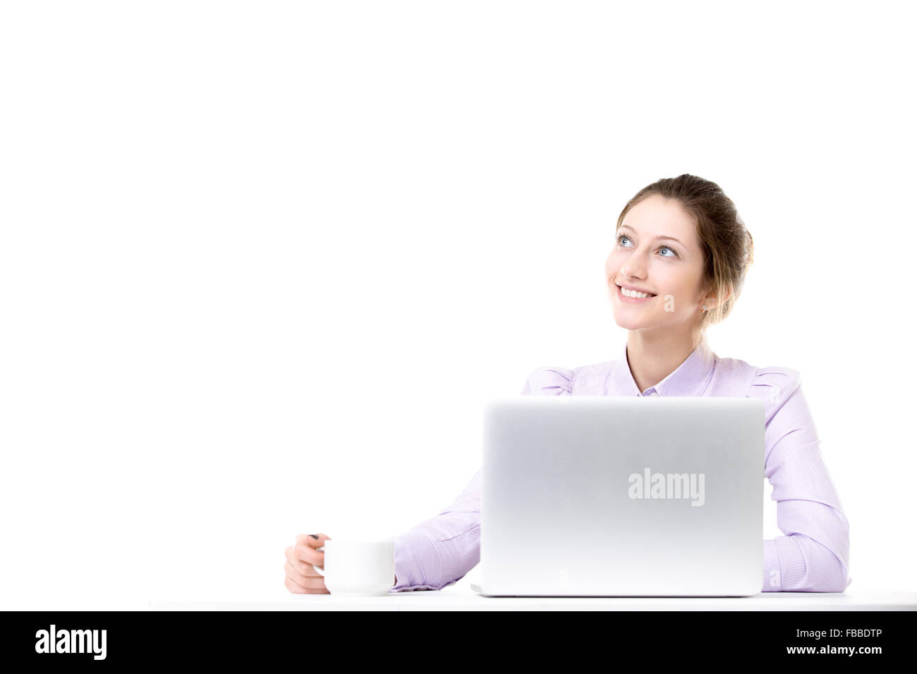 Sorridenti bella ragazza di office in appoggio con espressione sognante, rilassante con tazza di caffè nella parte anteriore del computer portatile, spazio di copia Foto Stock