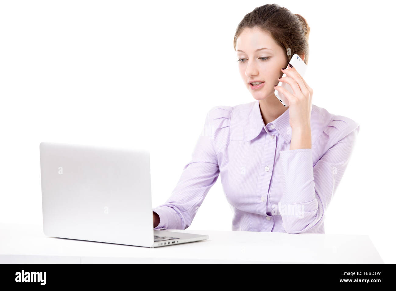 Bella ragazza di office in formale parlando di usura sul telefono cellulare e la digitazione sul portatile, ricevere gli ordini, tenendo business, chiamata Copia s Foto Stock