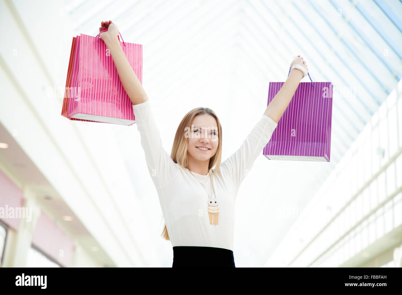 Buoni acquisti, buon umore, gioiosa giovane donna felice con il suo shopping, tenendo pila di sacchi di carta. Vendita, sconto, moda, Foto Stock