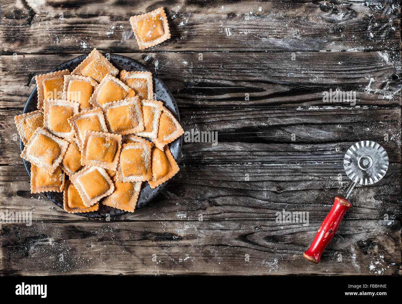 Ravioli di zucca. Freschi Fatti in casa i ravioli di zucca su un tavolo in legno e una taglierina vintage pasta. Foto Stock