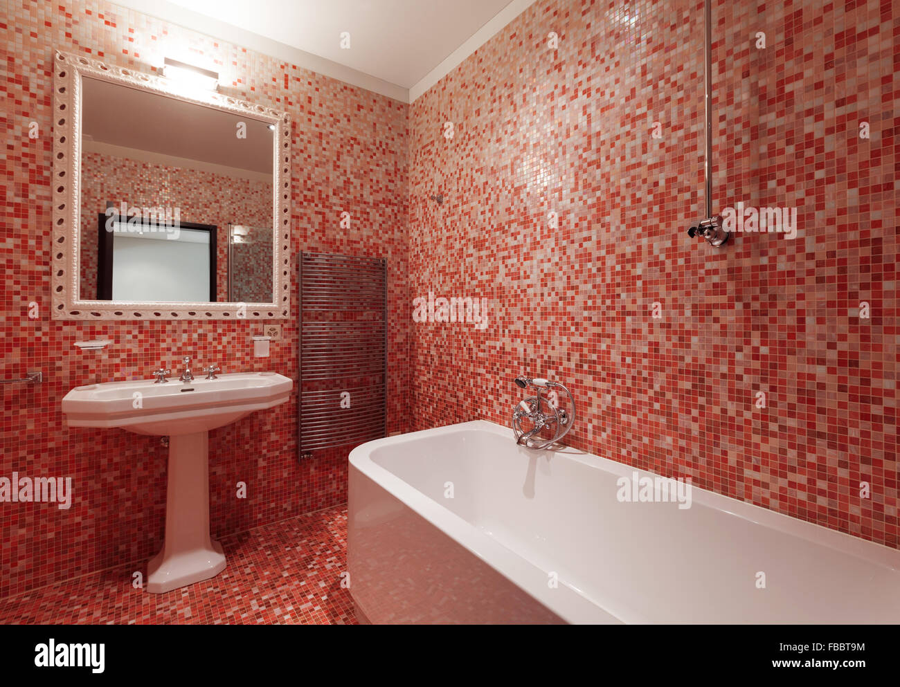 Bagno con piastrelle rosse e una vasca da bagno Foto Stock