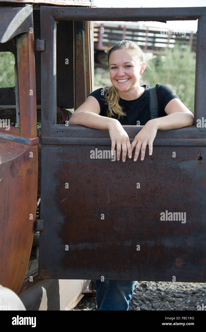 Giovane donna in posa di un vecchio carrello finestrino di portiera Foto Stock