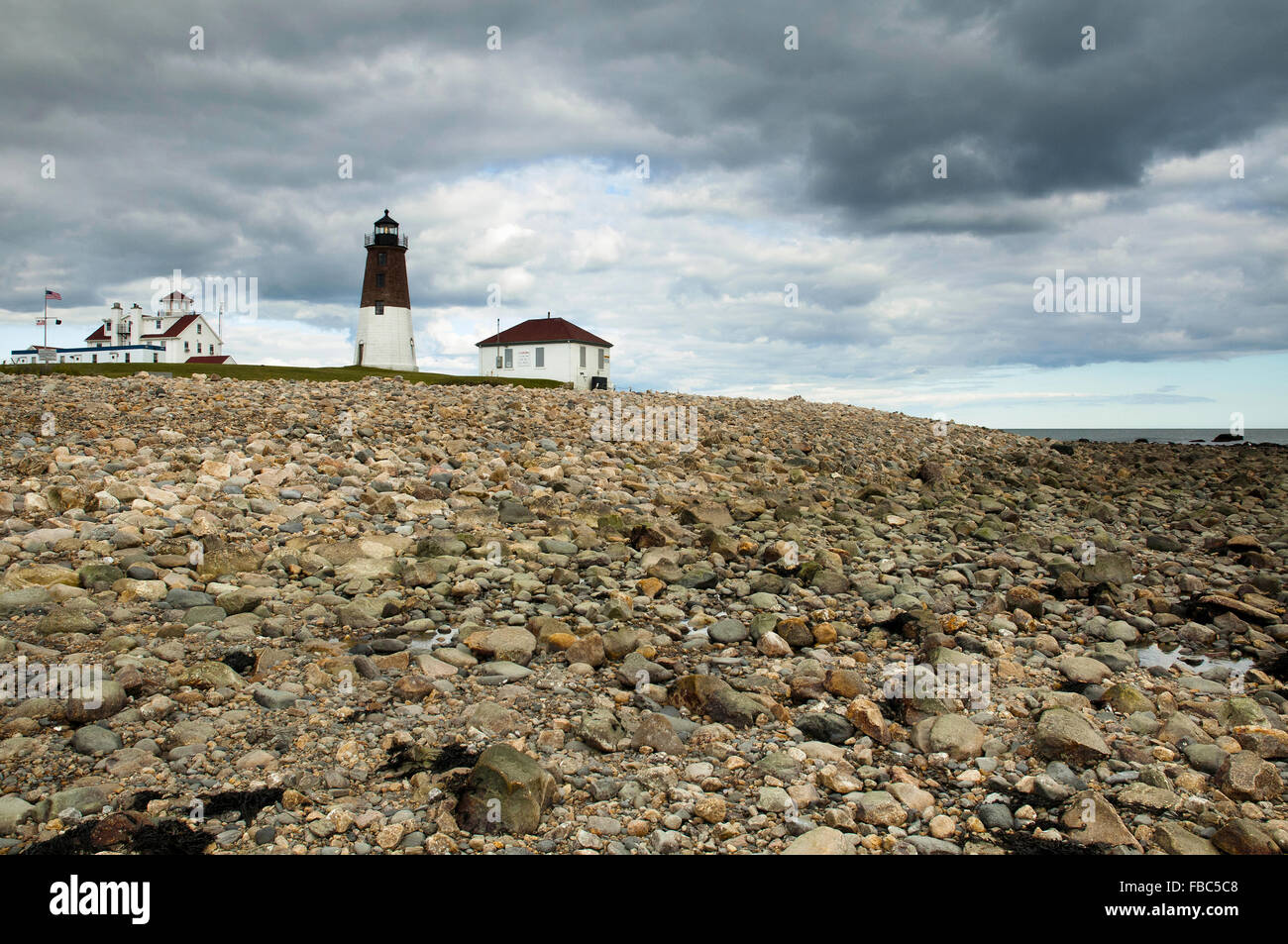 Punto Judith faro si trova lungo la costa rocciosa come approcci di tempesta in un giorno di estate nel sud del Rhode Island. Foto Stock