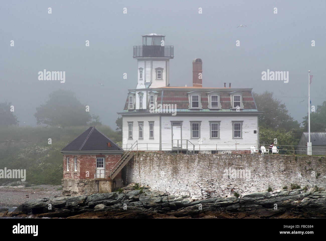 Rose Island Lighthouse di prima mattina nebbia estiva all'interno del porto di Newport, Rhode Island. Foto Stock