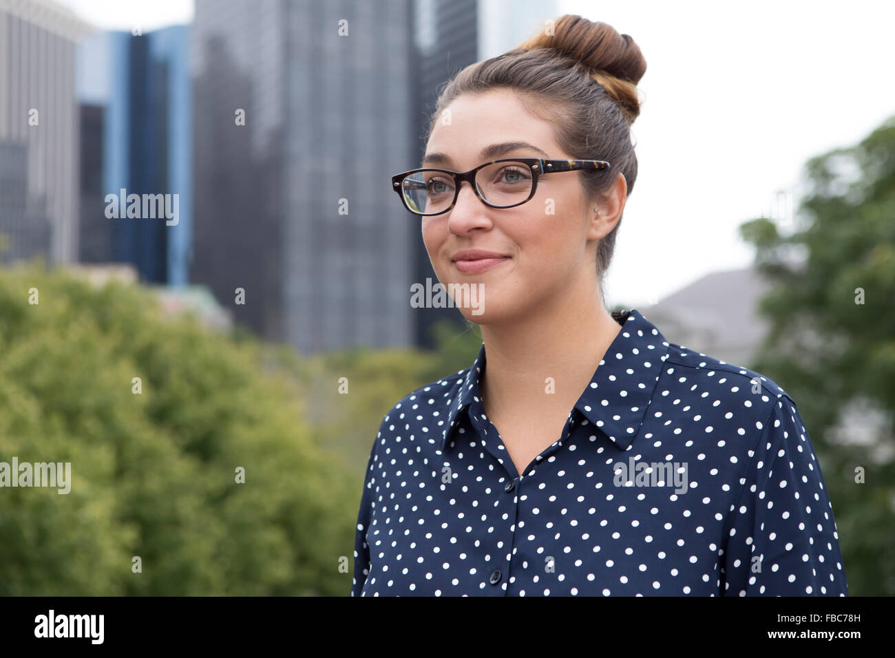 Girato a tenuta professionale di un giovane donna d'affari con un alto edificio in background. Fotografato a New York City, in O Foto Stock