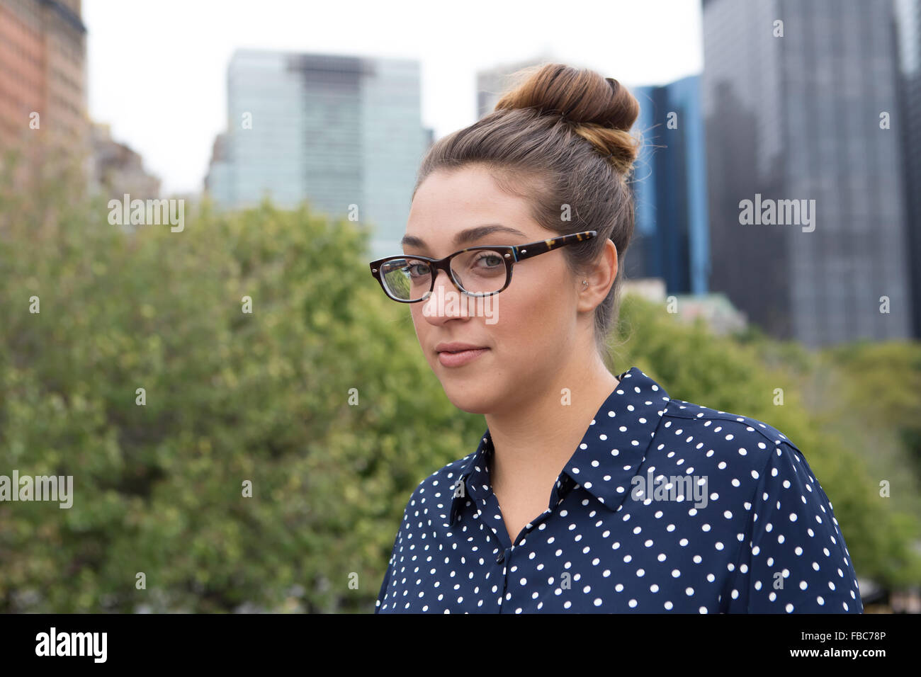 Girato a tenuta professionale di un giovane donna d'affari con un alto edificio in background. Fotografato a New York City, in O Foto Stock
