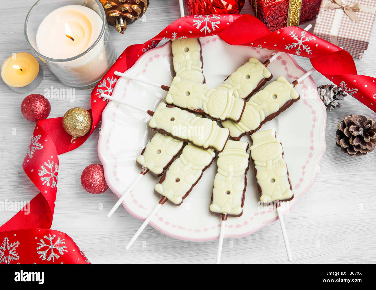 Cioccolatino natalizio di lecca-lecca tratta con nastro di festosa, Profumo candela,doni e sfere Foto Stock