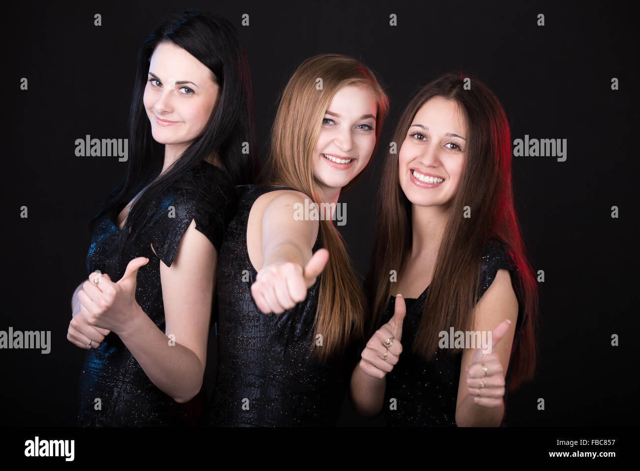 Migliori amici sorridenti che mostra Thumbs up, belle ragazze ritratto di gruppo, godendo il loro tempo Foto Stock