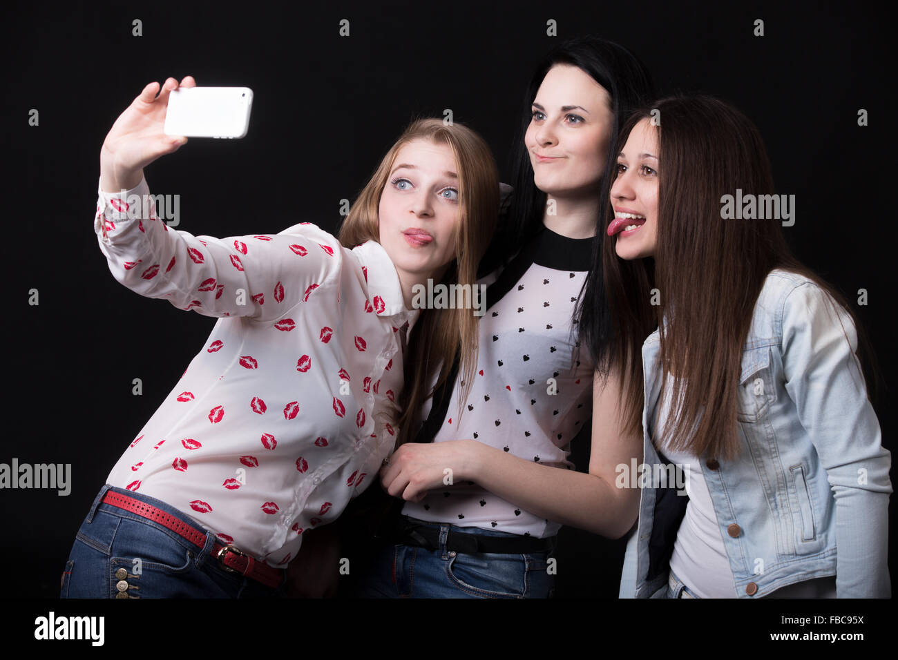 Gruppo di belle ragazze tirando facce buffe, tenendo selfie, autoritratto con lo smartphone, migliori amici sorridenti tog Foto Stock