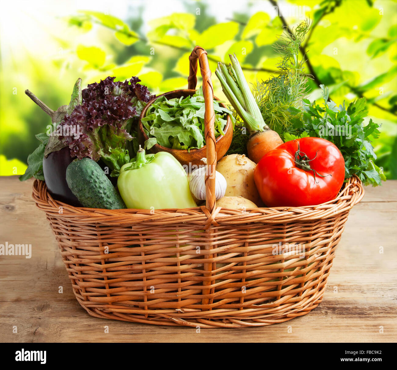Cesto di verdure con pomodoro, rucola,,l'insalata di melanzane, patate,  carote, aglio e verdi su tavola di legno in natura Foto stock - Alamy