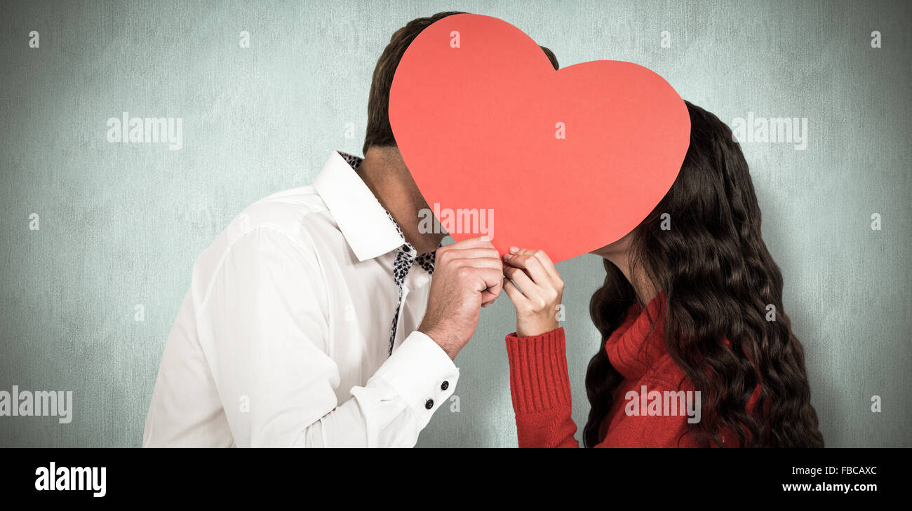 Immagine composita del giovane che copre i volti con cuore di carta Foto Stock