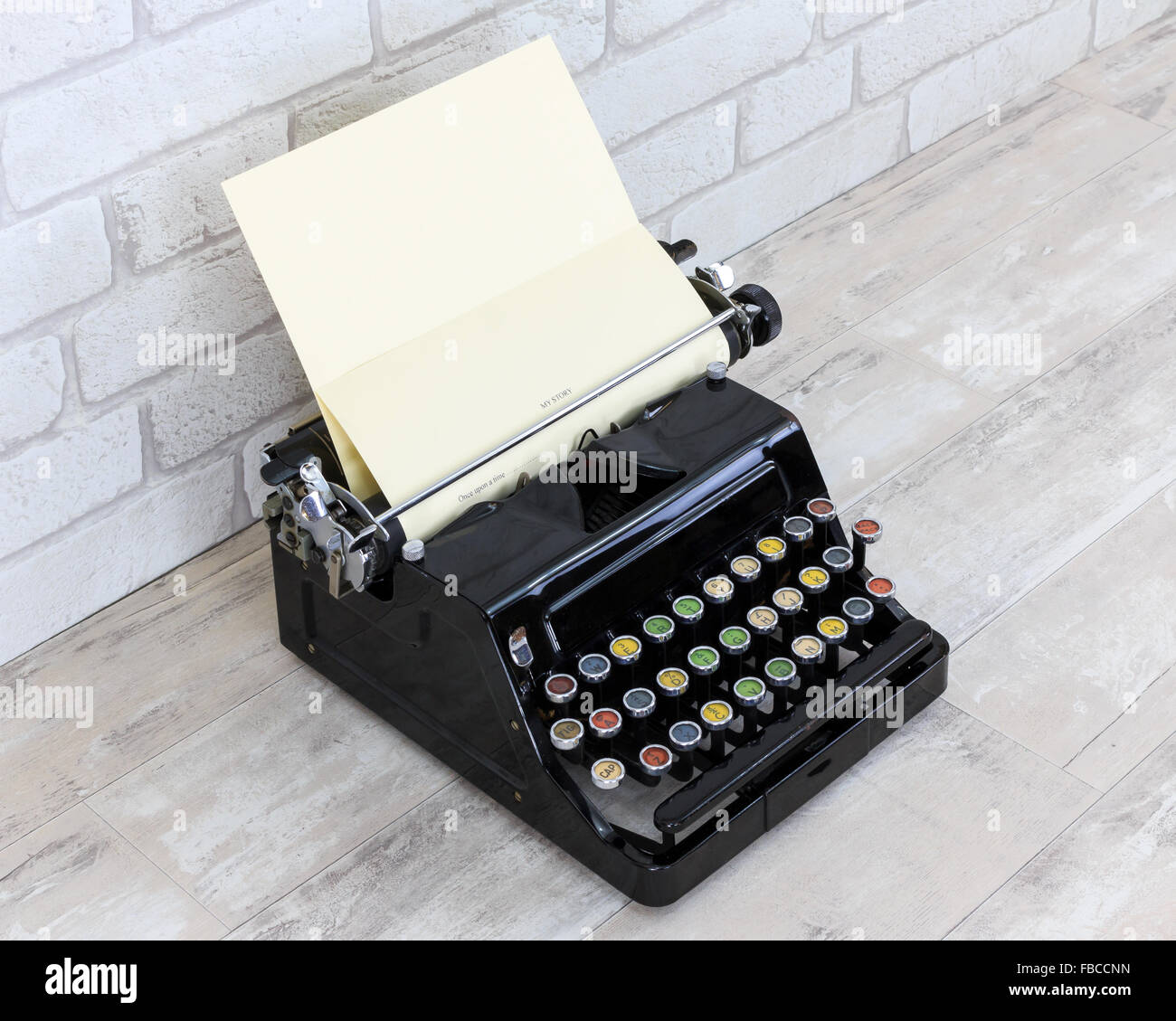 Vintage macchina da scrivere sul vecchio squallido effetto legno desk top con mattoni bianchi sullo sfondo di parete Foto Stock