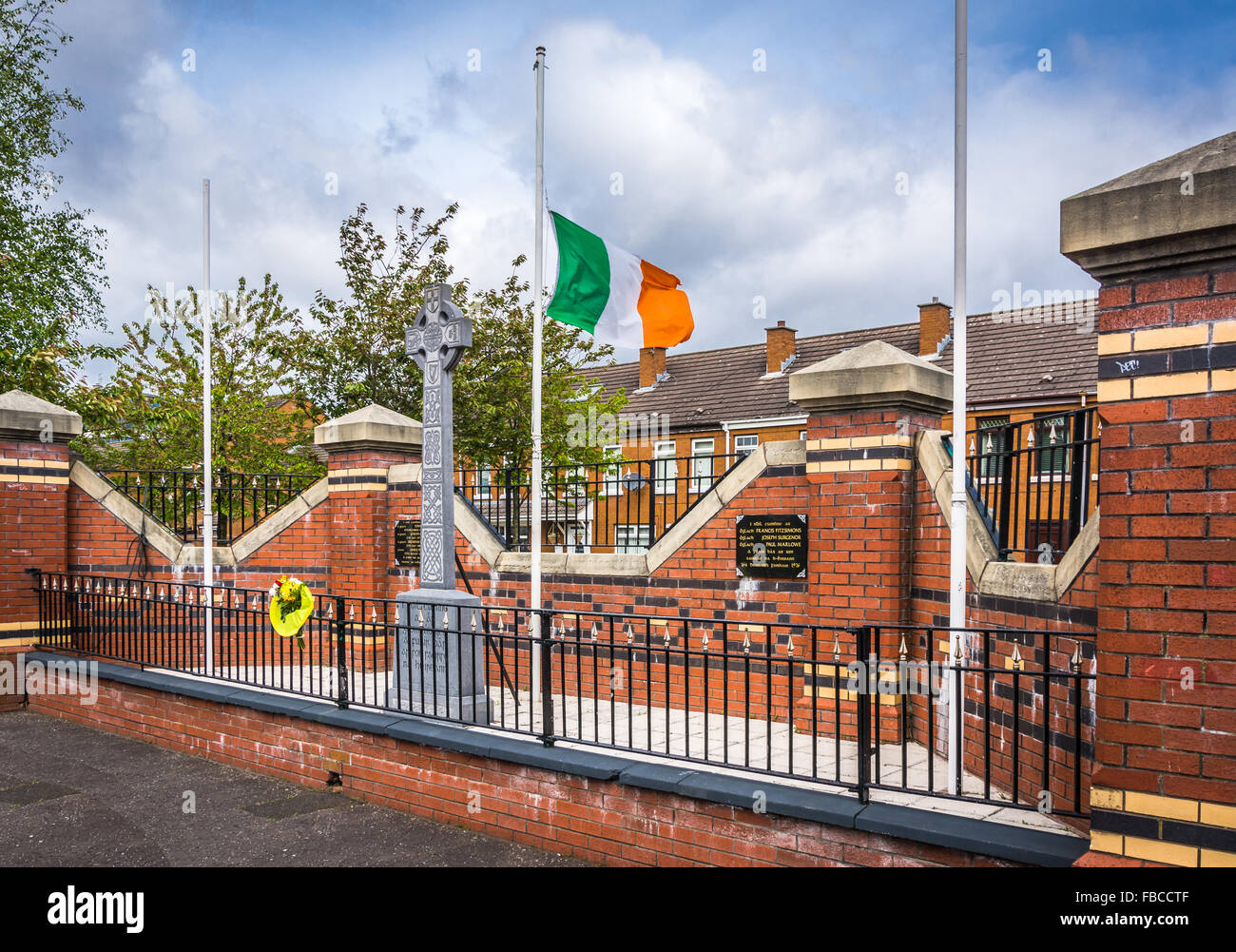IRA memorial garden in mercati zona di Belfast con il tricolore irlandese battenti a metà del montante. Foto Stock