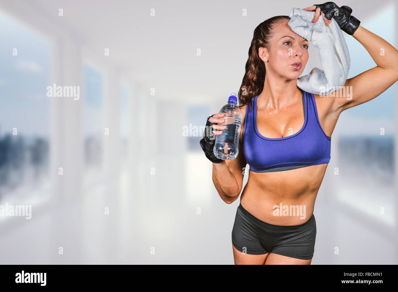 Immagine composita di esaurito donna tergi sudore tenendo la bottiglia di acqua Foto Stock