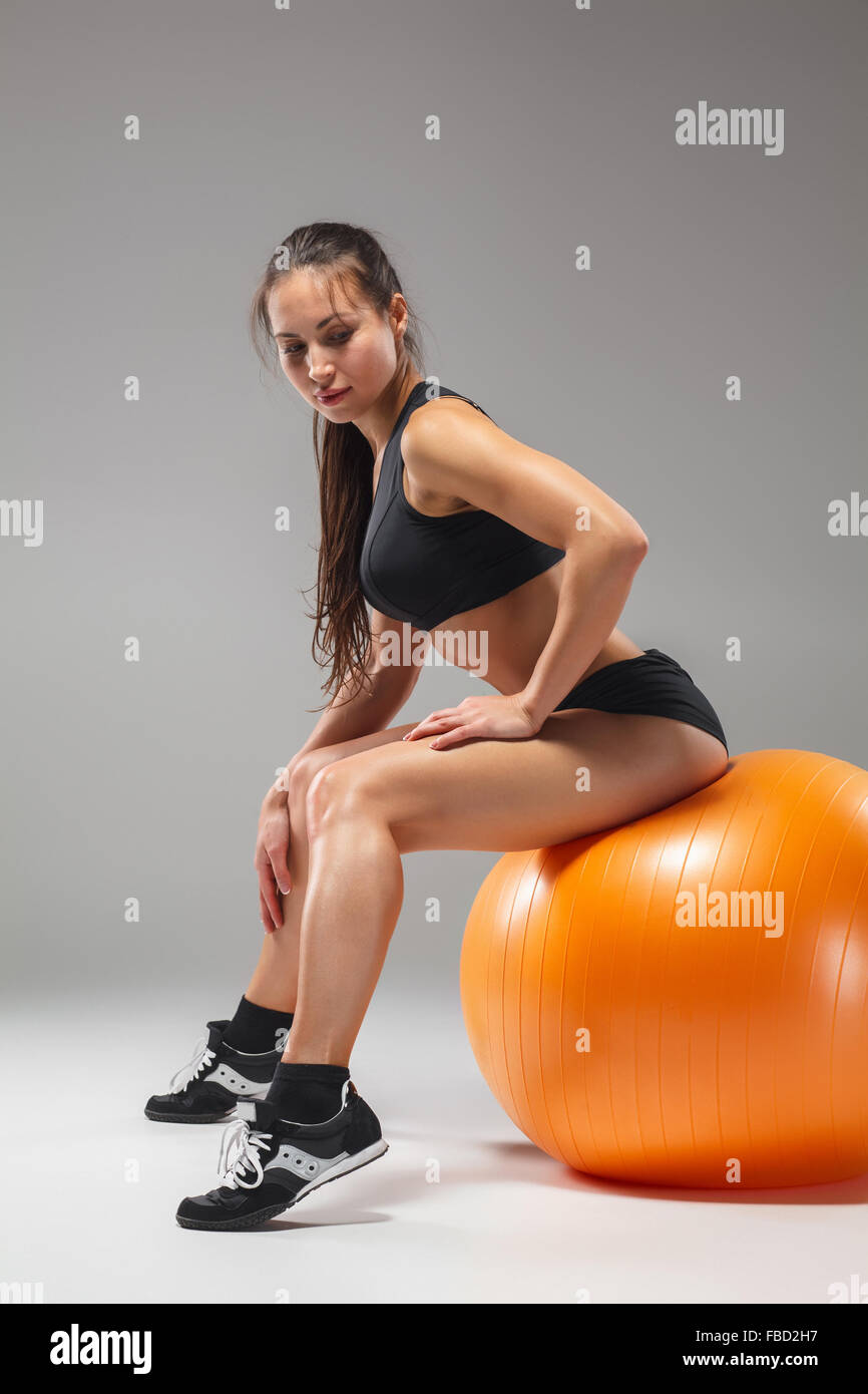 Il giovane, bella ragazza sportiva facendo esercizi su una fitball Foto Stock