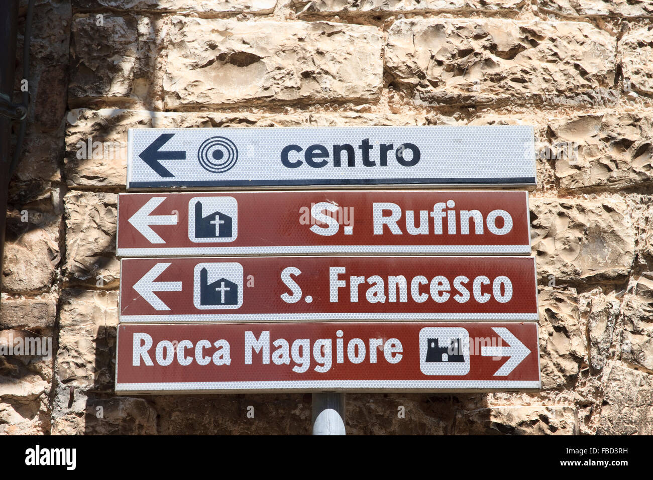 Segnaletica stradale italiana nella città di Assisi, Italia, che indica la strada per gli alberghi e i luoghi di interesse della zona. Foto Stock
