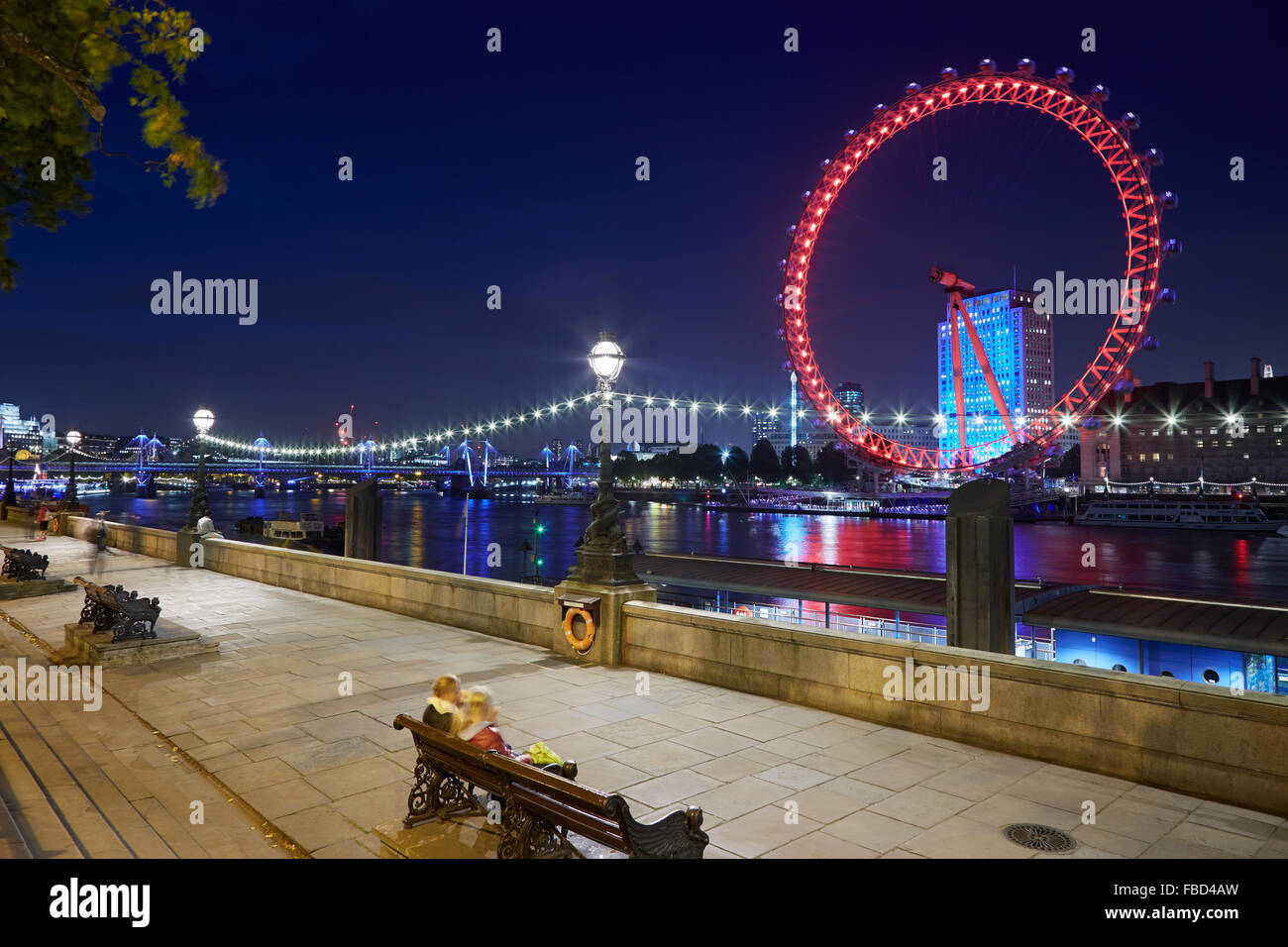 London Eye, ruota panoramica Ferris, illuminato in rosso nella notte e Thames river docks view Foto Stock